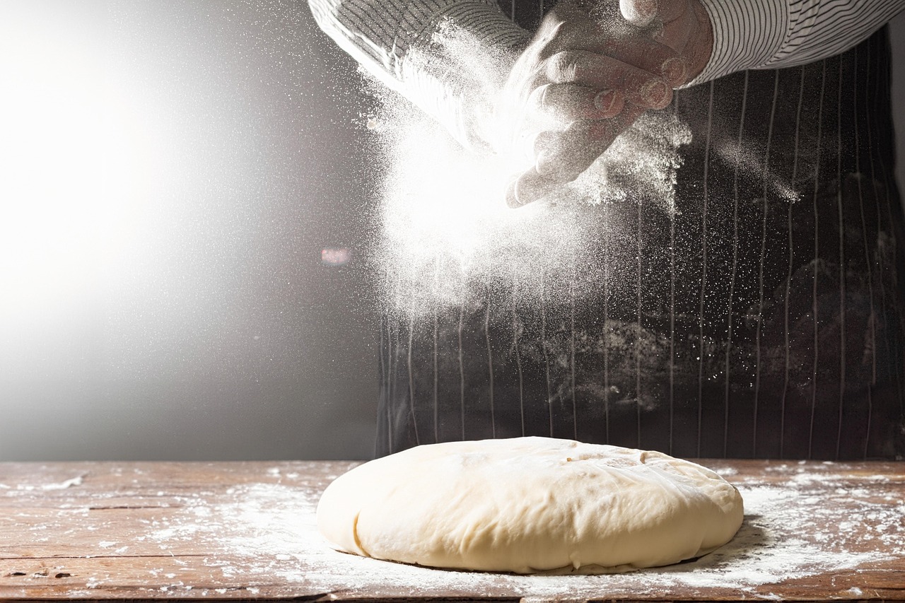 Hands preparing dough in a kitchen